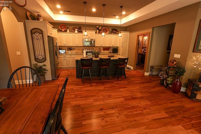 3826 Windsor Bridge Cir, Huron, OH 44839 - dining space with dark wood-style floors, a tray ceiling, arched walkways, and recessed lighting
