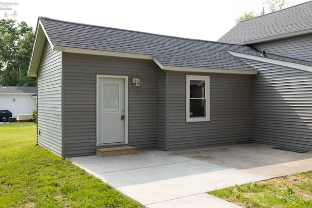 15 Abbott St, Wakeman, OH 44889 - entrance to property with a shingled roof, a yard, and a patio area