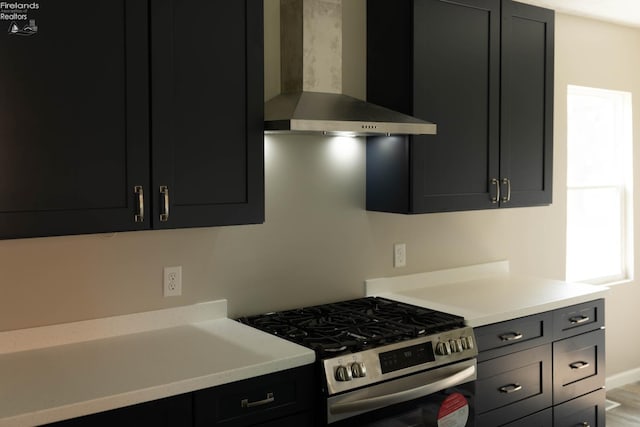 15 Abbott St, Wakeman, OH 44889 - kitchen featuring wall chimney range hood, stainless steel gas range oven, light countertops, and dark cabinetry