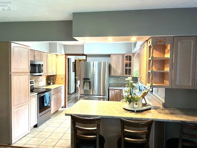 9 Eagle Way, Norwalk, OH 44857 - kitchen with appliances with stainless steel finishes, a peninsula, light countertops, and decorative backsplash