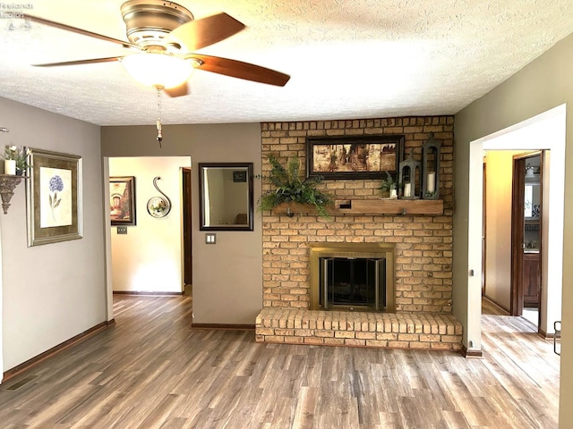 9 Eagle Way, Norwalk, OH 44857 - unfurnished living room with a textured ceiling, wood finished floors, ceiling fan, and a brick fireplace