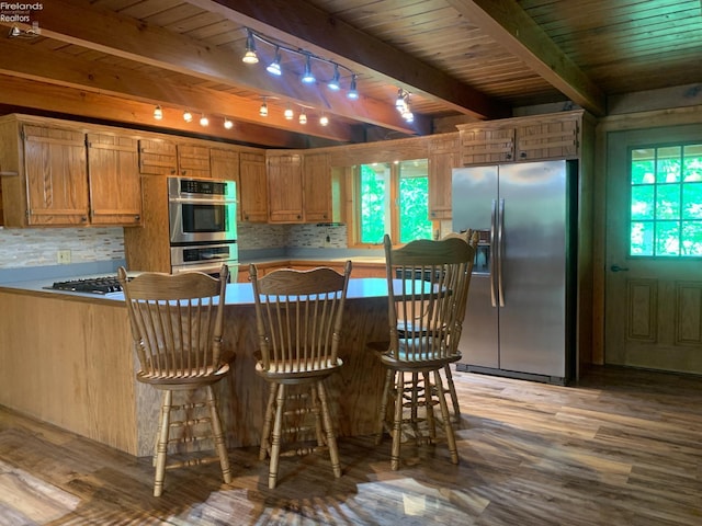37 State Route 60, New London, OH 44851 - kitchen with stainless steel appliances, wood finished floors, a wood ceiling with exposed beams, track lighting, and a kitchen breakfast bar
