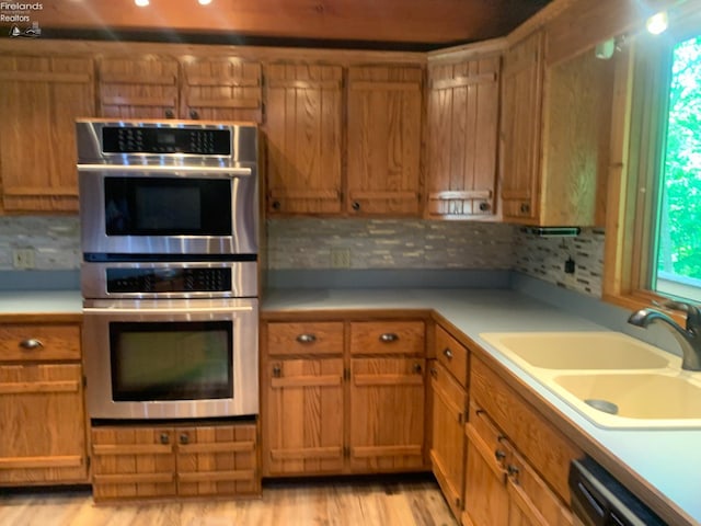 37 State Route 60, New London, OH 44851 - kitchen with stainless steel double oven, backsplash, brown cabinetry, and light countertops