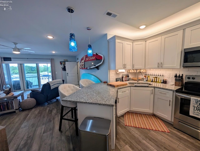 2620 S Waterside Ct Unit 622, Marblehead, OH 43440 - kitchen featuring stainless steel appliances, a peninsula, dark wood-type flooring, backsplash, and recessed lighting