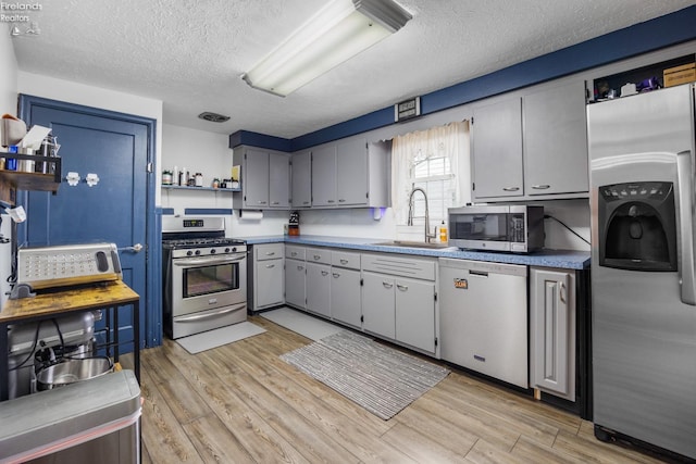46320 Middle Ridge Rd, Amherst, OH 44001 - kitchen with stainless steel appliances, a textured ceiling, light wood-style floors, and open shelves
