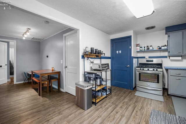 46320 Middle Ridge Rd, Amherst, OH 44001 - kitchen with open shelves, stainless steel gas range, a textured ceiling, light wood-style flooring, and light countertops