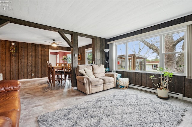 5191 N State Route 53, Tiffin, OH 44883 - living room featuring wooden walls, a ceiling fan, beam ceiling, baseboard heating, and wood finished floors