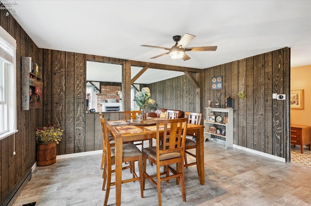 5191 N State Route 53, Tiffin, OH 44883 - dining area featuring wood walls, a ceiling fan, a baseboard radiator, wood finished floors, and a fireplace