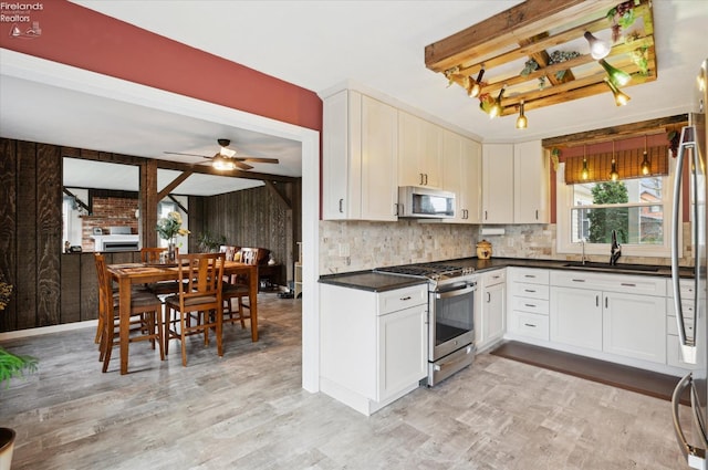 5191 N State Route 53, Tiffin, OH 44883 - kitchen with stainless steel appliances, light wood finished floors, tasteful backsplash, dark countertops, and ceiling fan