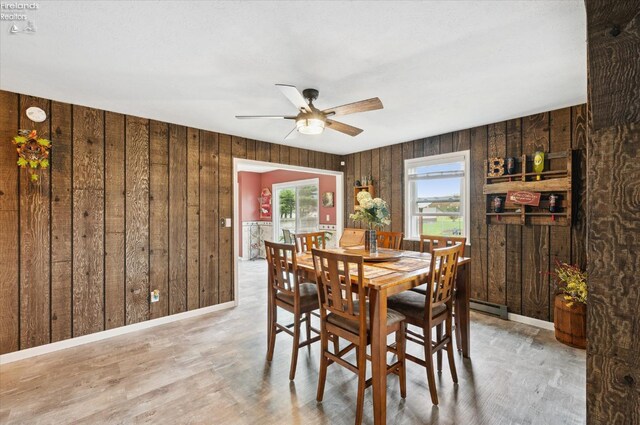 5191 N State Route 53, Tiffin, OH 44883 - dining area featuring wood walls, ceiling fan, wood finished floors, and baseboard heating