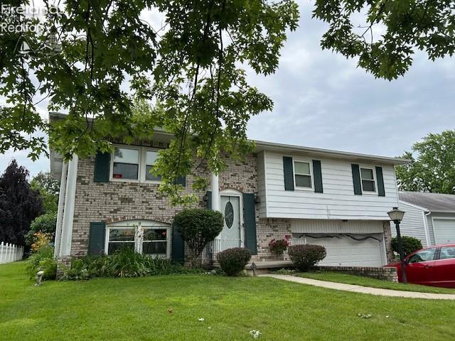 1441 White Ave, Fremont, OH 43420 - raised ranch with brick siding, a front yard, and an attached garage