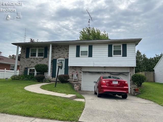 1441 White Ave, Fremont, OH 43420 - bi-level home featuring brick siding, an attached garage, and concrete driveway