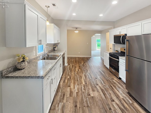 217 Ott St, Clyde, OH 43410 - kitchen featuring appliances with stainless steel finishes, dark wood-style floors, arched walkways, recessed lighting, and white cabinetry