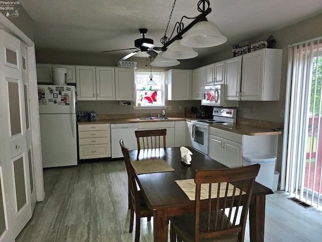 63 Williams Ave, Norwalk, OH 44857 - kitchen featuring white appliances, white cabinets, wood finished floors, ceiling fan, and hanging light fixtures