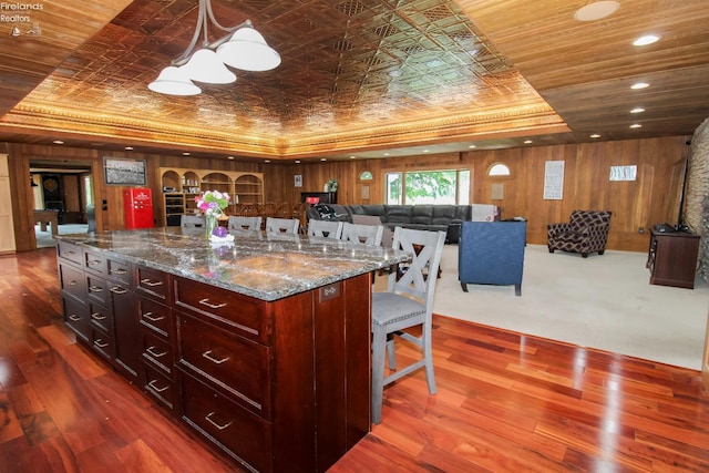 500 E State Route 61, Norwalk, OH 44857 - kitchen with a tray ceiling, a kitchen breakfast bar, dark stone counters, dark wood-style floors, and pendant lighting