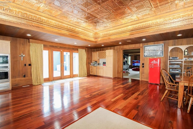 500 E State Route 61, Norwalk, OH 44857 - unfurnished living room featuring an ornate ceiling, hardwood / wood-style floors, wooden walls, french doors, and a raised ceiling