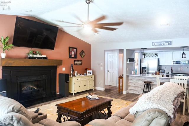 423 Leisure Dr, Huron, OH 44839 - living room featuring a ceiling fan, light wood-style flooring, lofted ceiling, and a fireplace with raised hearth