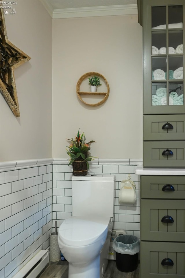 423 Leisure Dr, Huron, OH 44839 - half bath with tile walls, baseboard heating, crown molding, a wainscoted wall, and wood finished floors
