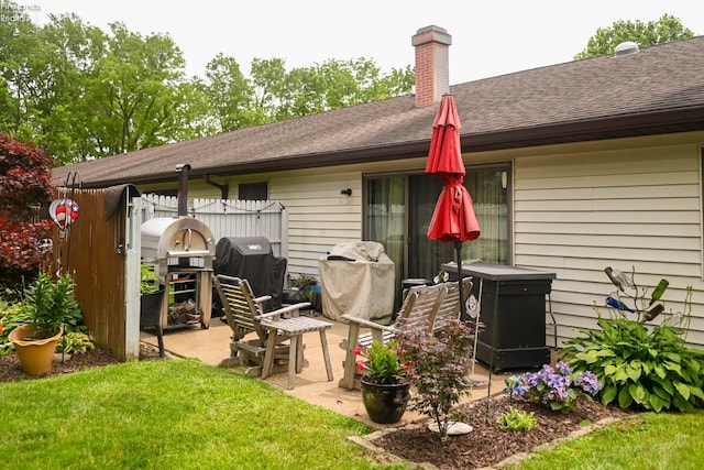 423 Leisure Dr, Huron, OH 44839 - back of property with roof with shingles, a chimney, and a patio