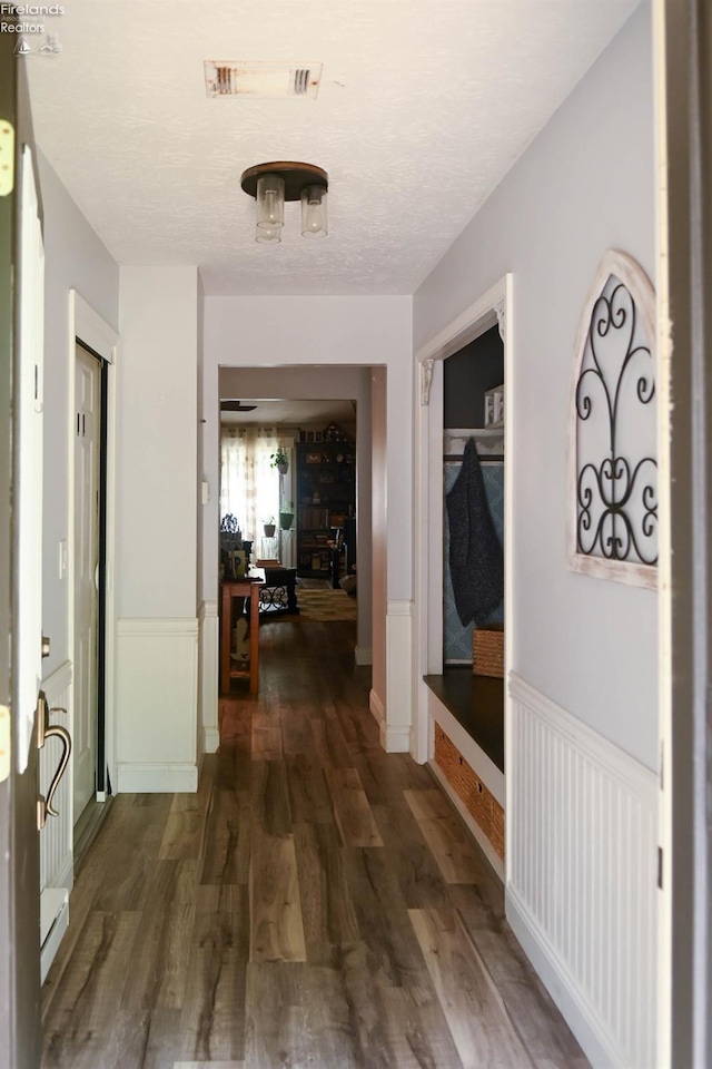 423 Leisure Dr, Huron, OH 44839 - hall with dark wood finished floors, wainscoting, and a textured ceiling