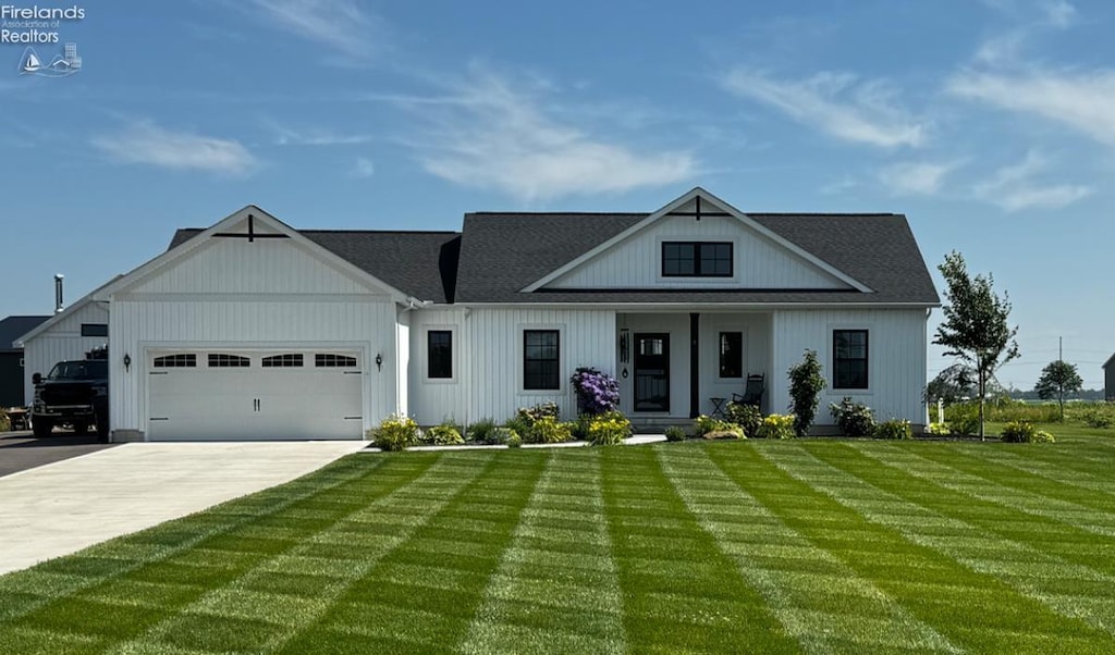 3508 Boos Rd, Huron, OH 44839 - modern inspired farmhouse with a front lawn, a garage, concrete driveway, and a porch
