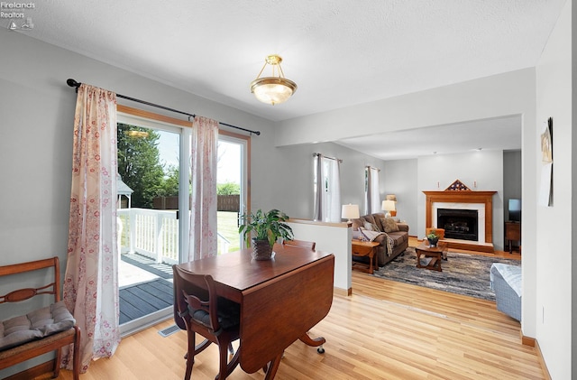 408 Forest St, Lagrange, OH 44050 - dining area with light wood-style flooring and a fireplace with raised hearth