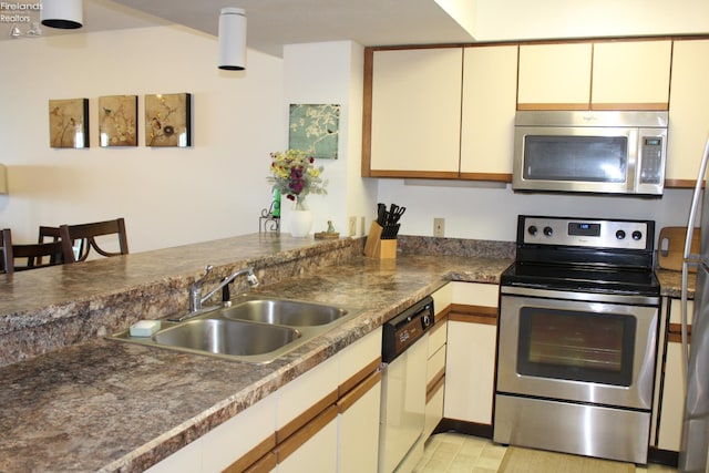 1507 Cleveland Rd Unit 423, Huron, OH 44839 - kitchen featuring stainless steel appliances, a peninsula, cream cabinetry, and dark countertops