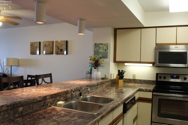 1507 Cleveland Rd Unit 423, Huron, OH 44839 - kitchen featuring appliances with stainless steel finishes, cream cabinetry, a peninsula, dark countertops, and a ceiling fan