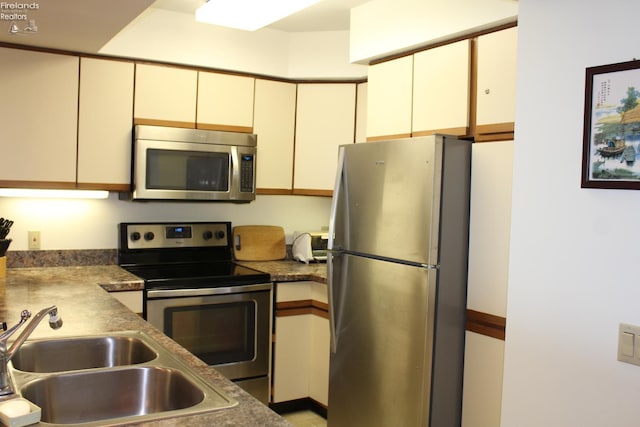 1507 Cleveland Rd Unit 423, Huron, OH 44839 - kitchen with stainless steel appliances, cream cabinetry, and dark countertops