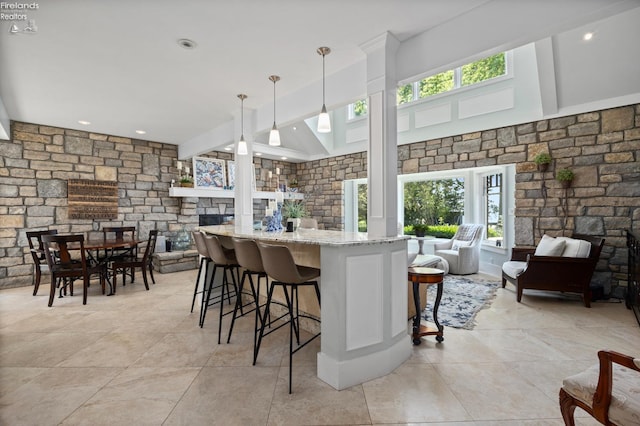 1115 Cedar Point Rd, Sandusky, OH 44870 - kitchen featuring plenty of natural light, open floor plan, light stone countertops, a breakfast bar area, and beam ceiling