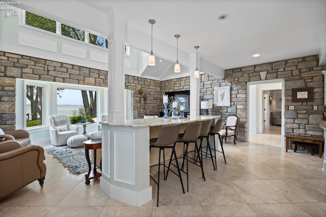 1115 Cedar Point Rd, Sandusky, OH 44870 - kitchen with open floor plan, light stone counters, a kitchen breakfast bar, and light tile patterned floors