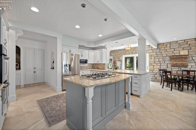 1115 Cedar Point Rd, Sandusky, OH 44870 - kitchen featuring stainless steel appliances, a peninsula, light stone countertops, a center island, and white cabinets
