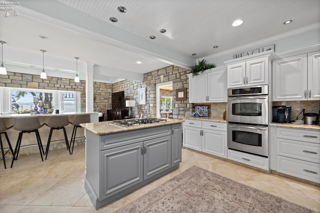 1115 Cedar Point Rd, Sandusky, OH 44870 - kitchen featuring appliances with stainless steel finishes, tasteful backsplash, a center island, gray cabinets, and white cabinetry