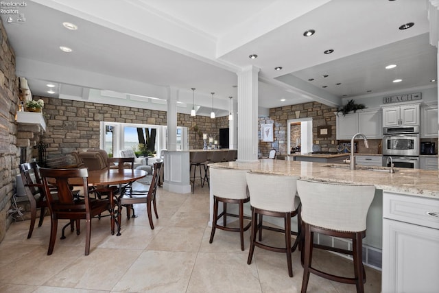 1115 Cedar Point Rd, Sandusky, OH 44870 - kitchen with light stone countertops, a fireplace, a kitchen breakfast bar, stainless steel double oven, and recessed lighting