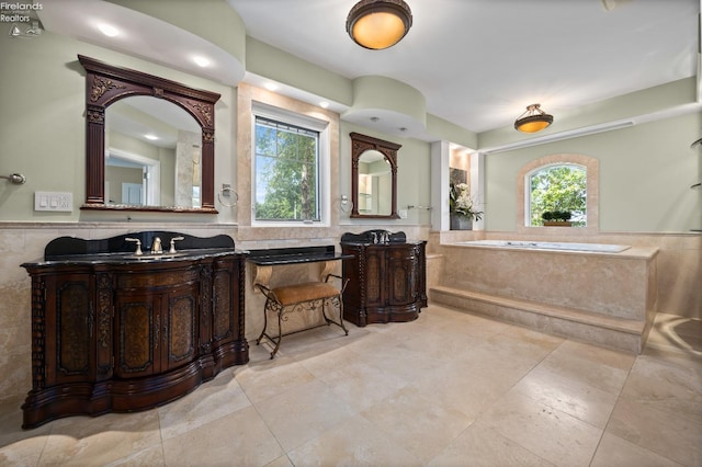 1115 Cedar Point Rd, Sandusky, OH 44870 - bathroom with tile walls, a garden tub, vanity, a wainscoted wall, and tile patterned floors