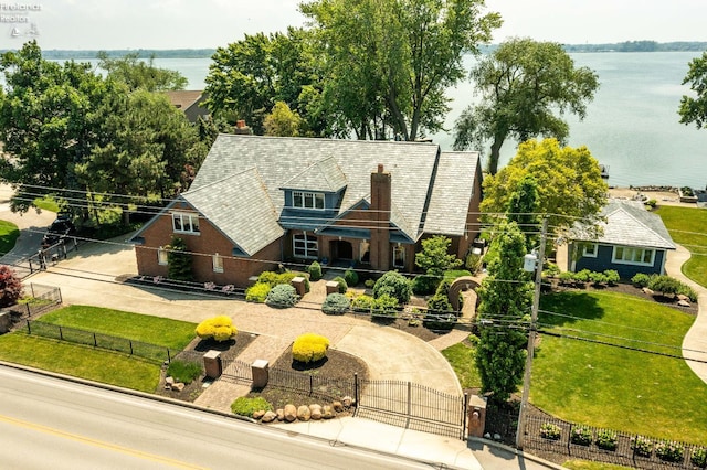 1115 Cedar Point Rd, Sandusky, OH 44870 - english style home with a fenced front yard, a gate, a water view, and driveway
