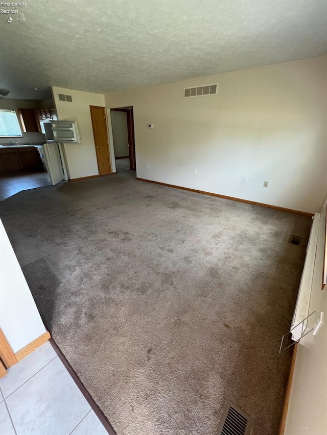3106 E County Road 50, Tiffin, OH 44883 - unfurnished living room featuring a textured ceiling, carpet floors, and tile patterned floors