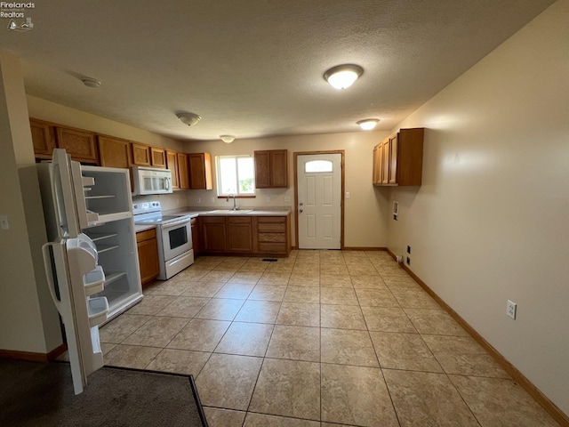 3106 E County Road 50, Tiffin, OH 44883 - kitchen featuring white appliances, brown cabinets, light countertops, and light tile patterned floors