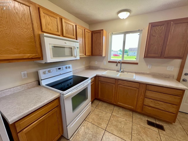3106 E County Road 50, Tiffin, OH 44883 - kitchen featuring white appliances, light countertops, brown cabinets, a textured ceiling, and light tile patterned floors
