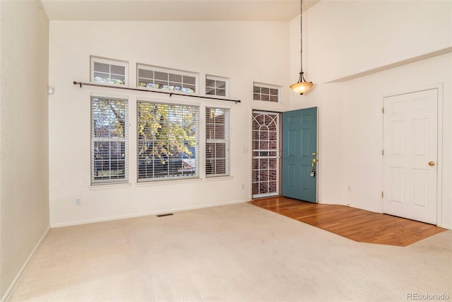 interior space with wood-type flooring and high vaulted ceiling