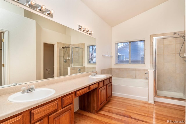 bathroom featuring hardwood / wood-style floors, vanity, independent shower and bath, and vaulted ceiling