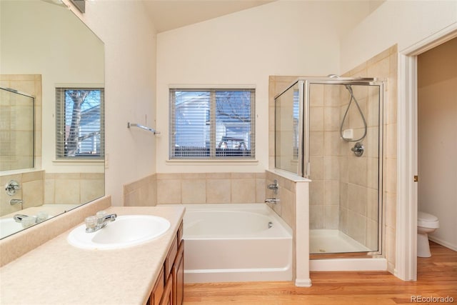 full bathroom featuring hardwood / wood-style flooring, vanity, toilet, and vaulted ceiling