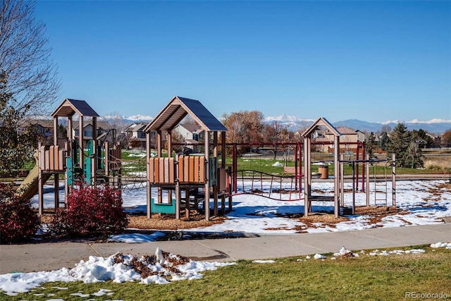 snow covered playground featuring a mountain view