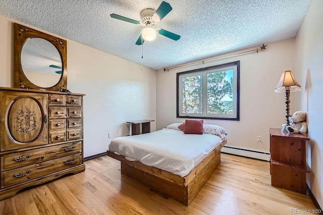 bedroom with a textured ceiling, light hardwood / wood-style floors, baseboard heating, and ceiling fan