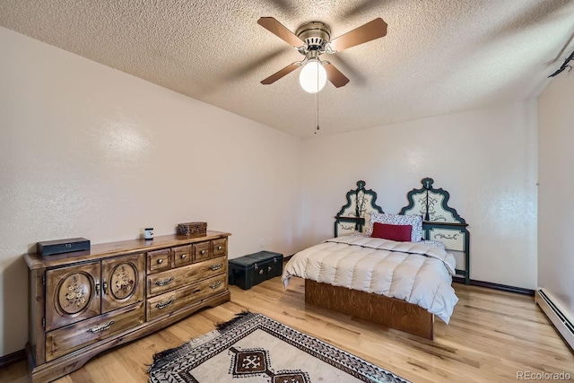 bedroom with ceiling fan, a textured ceiling, light hardwood / wood-style flooring, and baseboard heating