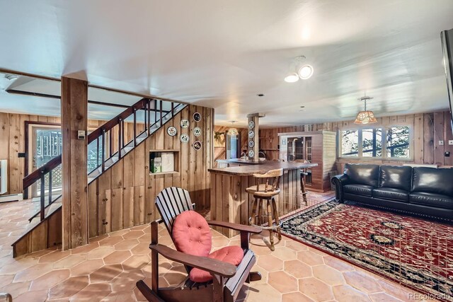 living room with bar area and wooden walls