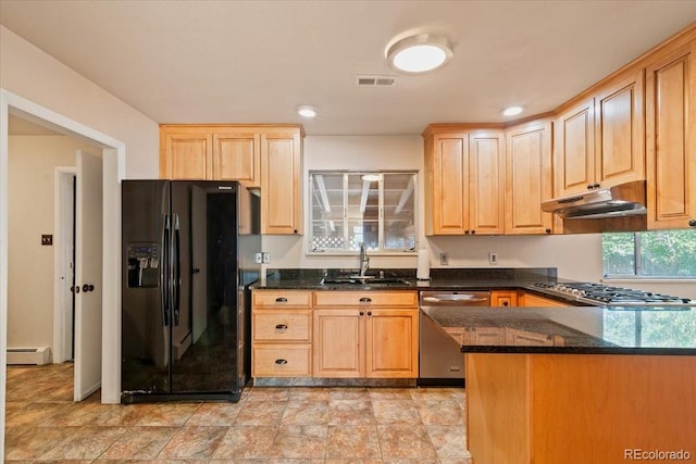 kitchen featuring dark stone countertops, kitchen peninsula, stainless steel appliances, sink, and a baseboard heating unit