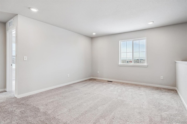 unfurnished room with carpet and a textured ceiling