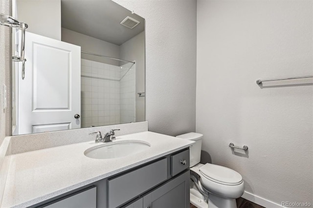 bathroom with vanity, toilet, and a shower