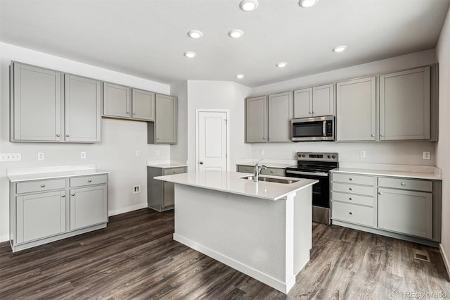 kitchen featuring appliances with stainless steel finishes, dark hardwood / wood-style flooring, sink, and gray cabinetry